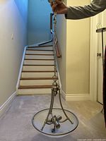 Photo showing full pendant light fixture held by chain, metal frame and glass shade visible.