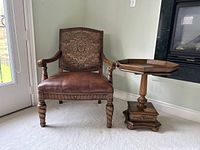 Full view of the accent chair and side table together showing matching wood finish and style.