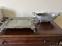 Both ornate metal tray and bowl displayed on wooden surface, showing the full set.
