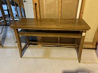 Side view of the wooden side table showing the stain on the top surface and the lower shelf.