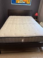 Full view of queen size sleigh style bed frame with mattress in bedroom.