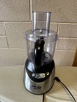Black & Decker food processor fully assembled showing base with controls, clear plastic bowl, lid, and feed chute.