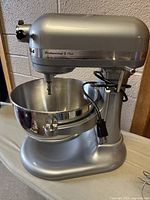 Side view of silver mixer with stainless steel bowl and cord wrapped