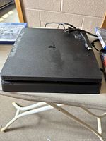 PS4 console with visible tape residue and cables on a table