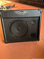 Front view of Traynor TVM10 amplifier showing black metal grille and brand logo.