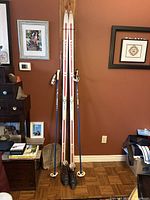 Full view of the two white and red Rossignol skis standing with attached Salomon automatic bindings, brown SNS ladies boots and blue/white ski poles leaning beside them