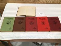 Six hardcover Dave Dawson books laid out with one open showing damage