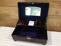 Open music box showing velvet interior, mirror and compartments