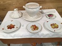 Overall view showing soup tureen set with ladle and three German plates