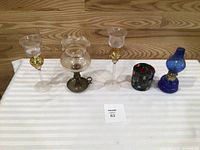 Group of five decorative lighting pieces lined up on table