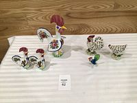 Group shot of six rooster/chicken figurines on table