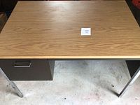 Top view showing oak-pattern laminate surface with paper lot tag