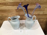 Two white Alfred Meakin pitchers, one holding three trumpet glass flowers