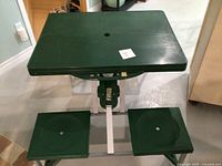 Overall view of unfolded picnic table showing tabletop, two attached seats and frame