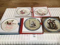 Group of five plates in boxes on table