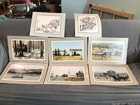 All eight unmatted prints and sketches displayed on sofa