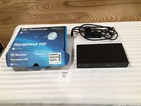 Receiver with box, power adapter and lot tag visible