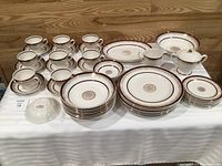 Full set displayed on table showing plates, bowls, cups, saucers, serving pieces