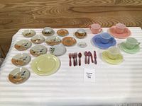 Full layout of ceramic plates, pastel cups, saucers, forks