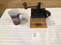 Grinder and mug side by side on striped cloth