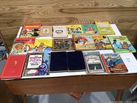 All 18 books laid out on table showing covers and relative sizes