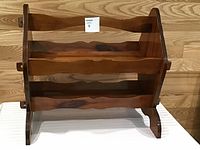 Front view of wooden magazine rack showing two shelves and scalloped edges