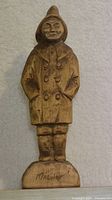 Front view of wooden folk art carving of sailor showing full figure and signed base