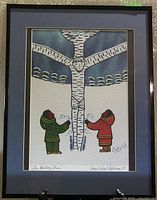 Full view of the framed print showing the complete artwork with two figures, tree, and frame.