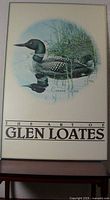 Full view of the poster on board showing the framed border and title 'The Art of Glen Loates' with image of a Common Loon.