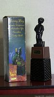 Full product with original box showing Bonnie Boy liquor dispenser and Manneken Pis statue figurine.