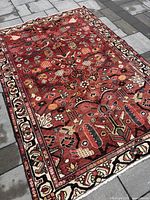 Full view of rug laid on stone surface showing entire design and border