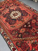 Close-up angle showing the central medallion and main motifs on the rug's surface, highlighting the color richness and design detail.