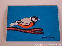 Photo of original canvas mounted painting of a bird on a blue background signed by David Morrisseau.