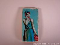Front view of Kelly Grace painting featuring a woman holding a red rotary phone against a blue and teal background.