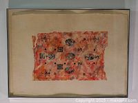 Front view of framed watercolor artwork titled Fragments by Margaret Priest, showing abstract orange and red rectangular composition set in metal frame on white background