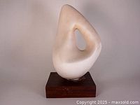 Front view of white marble sculpture on wood base