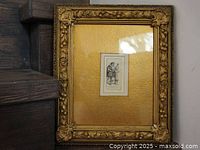 Front view of ornate gold-tone molded frame containing small Rembrandt etching under glass