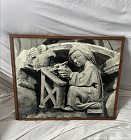 Frontal photo of framed black and white image showing a stone carving of a seated figure holding an object with a bird figure above, wooden frame, size estimated 16x20 inches