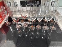 Photo of ten pink depression glass items including wine glasses and champagne flutes lined up on stove