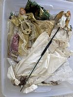 Tote container open showing multiple Christmas angel figurines and fabric decorations inside.