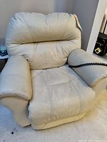 Front view of a beige leather electric recliner chair showing padded armrests and cushioned seat and back.