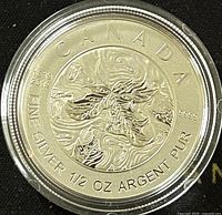 Obverse side of silver coin with stylized maple leaf design and purity details.