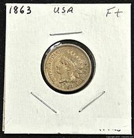 Obverse side of 1863 US Indian Head penny. Shows Indian head portrait and date '1863' with 'UNITED STATES OF AMERICA' inscription.