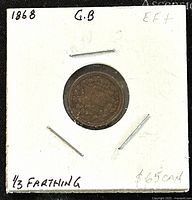 Front side of the 1868 GB Queen Victoria 1/3 Farthing bronze coin in cardboard holder showing date and denomination.