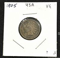 Obverse view of 1905 US Indian Head penny mounted in a white cardboard holder showing Lady Liberty in Native American headdress and date 1905 with VG noted on holder.