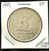 Reverse side of 1949 Canadian silver dollar coin showing ship Blagdon Nova, labeled 'CANADA DOLLAR 1949'. Coin set in white protective holder stamped with '1949', 'EF', and 'SILVER 80%'.