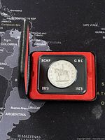 Opened case showing the side of coin with RCMP officer on horseback and dates 1873-1973