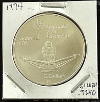 Reverse side showing a male rower and inscriptions "Olympiade XXI Olympiad Montreal 1976 5 Dollars" and Olympic rings symbol.