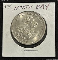 Obverse side of the 1975 Canadian North Bay Ontario trade dollar coin showing City of North Bay imagery and dates 1925-1975.