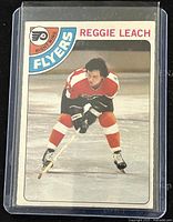 Front of the 1978-79 O-Pee-Chee Reggie Leach hockey card with player image and Flyers logo.